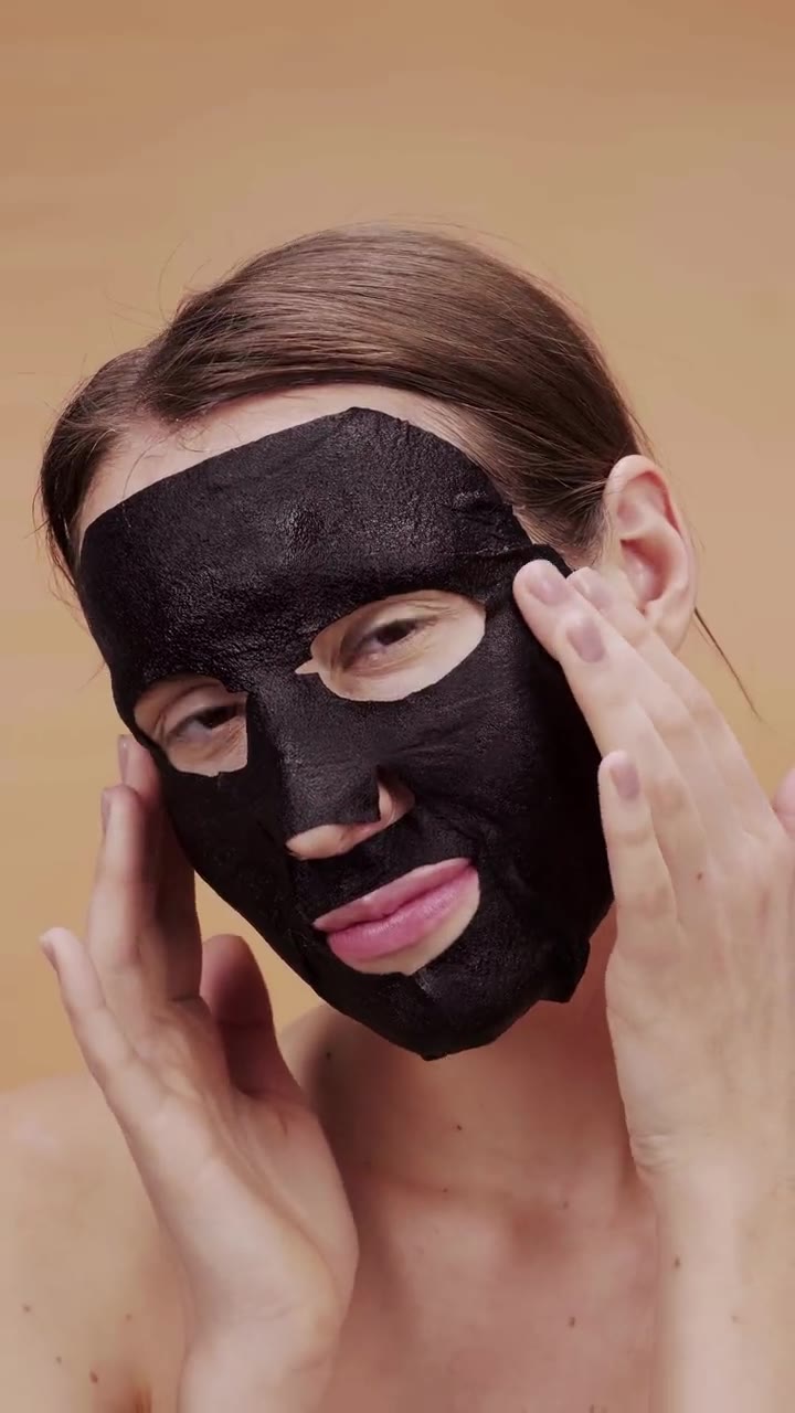 Modelo tirando uma máscara facial preta