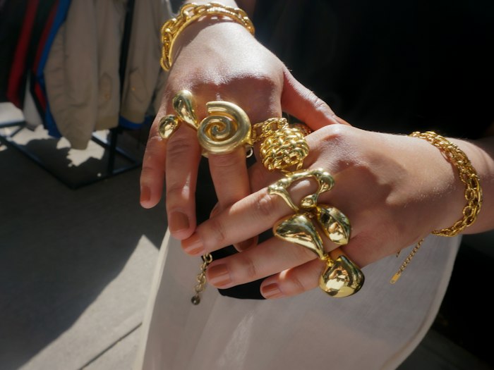 Mãos com anéis e pulseiras douradas