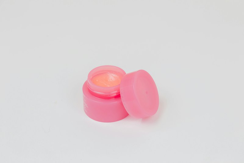 Pote rosa de tampa redonda sobre fundo branco