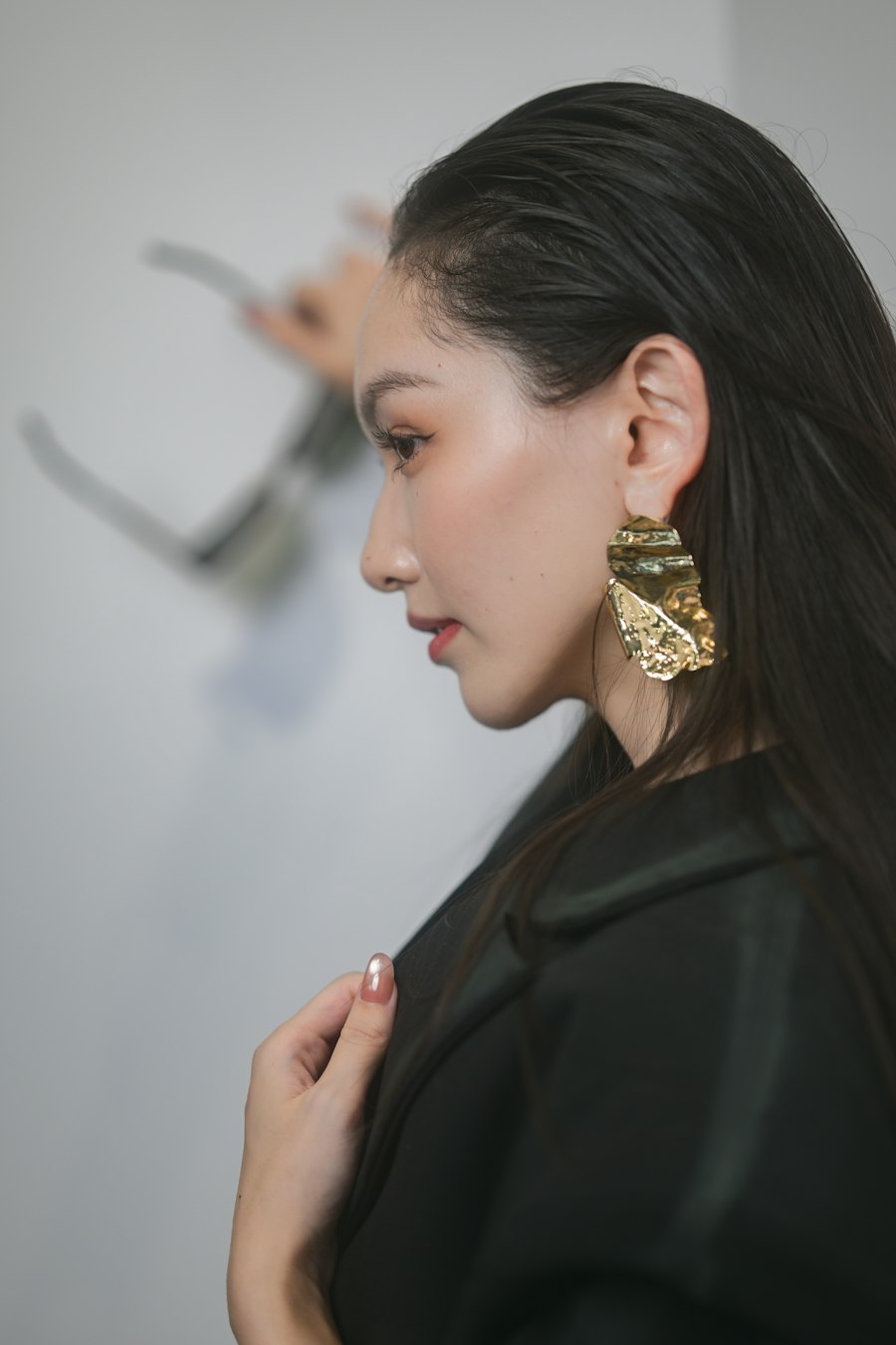 Mulher de perfil com brinco dourado grande