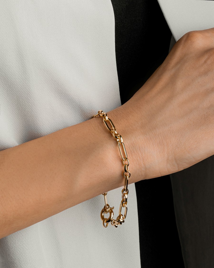 Close de pulso com pulseira dourada