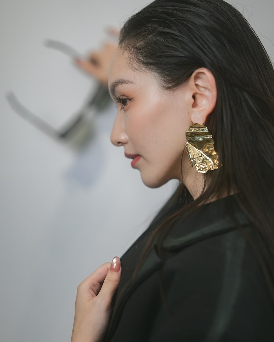 Mulher de perfil com brinco dourado texturizado